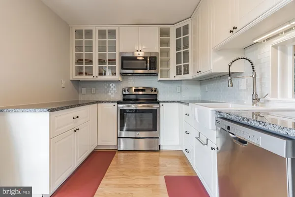 a kitchen with stainless steel appliances granite countertop a stove a sink and a microwave