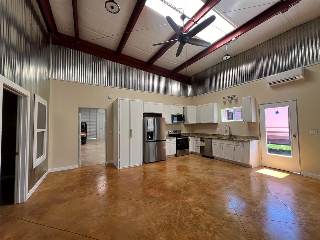 a large hall with stainless steel appliances wooden floor and living room view