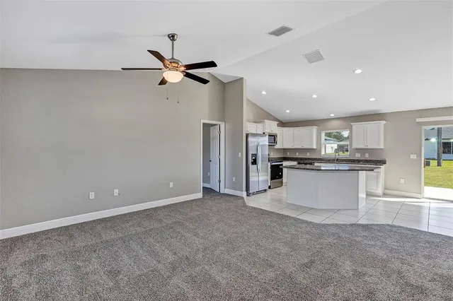 a view of a kitchen with a sink and dishwasher a refrigerator with wooden floor