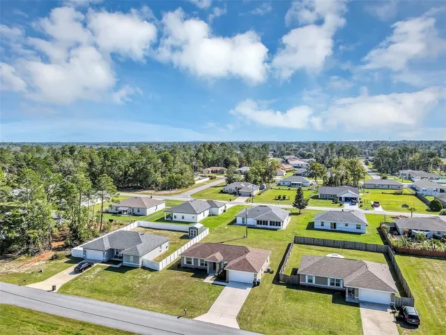 an aerial view of residential houses with outdoor space and swimming pool