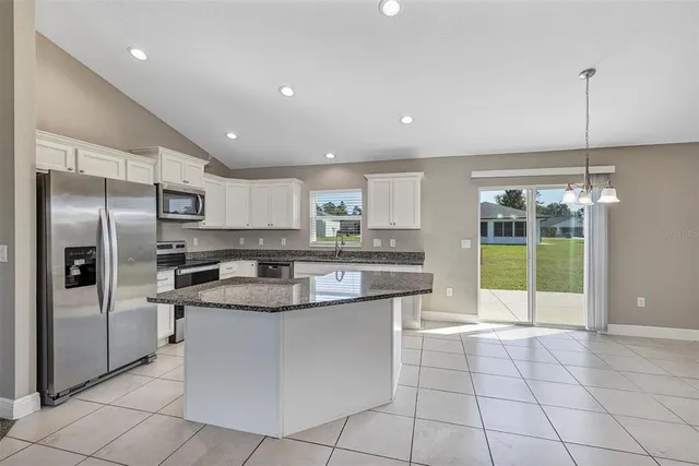 a kitchen with stainless steel appliances granite countertop a sink a stove and a refrigerator