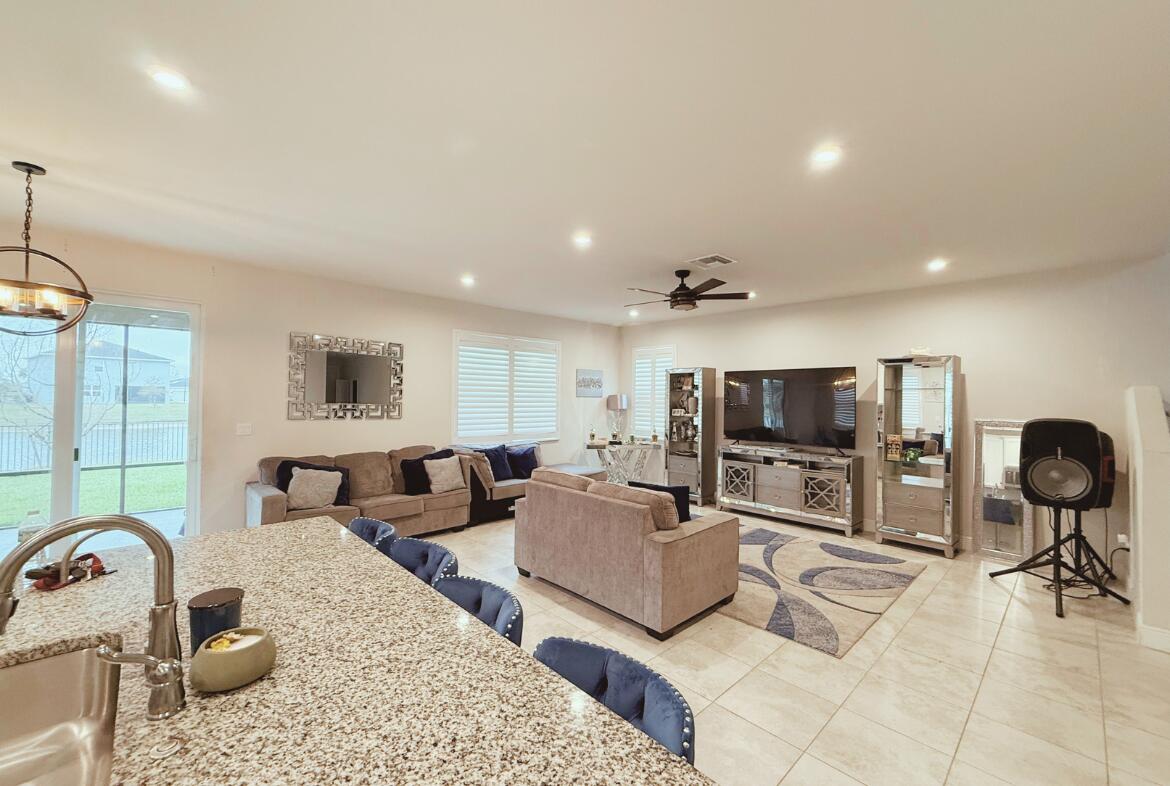 11024 Pacini Way Port St. Lucie, FL 34987 - Photo 15 of 16 a living room with furniture a flat screen tv and kitchen view