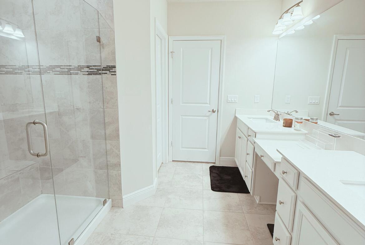 11024 Pacini Way Port St. Lucie, FL 34987 - Photo 5 of 16 a bathroom with a granite countertop sink a mirror and shower