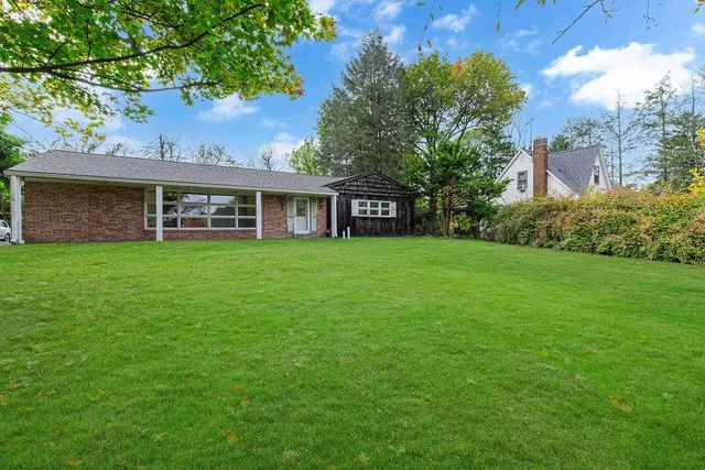 a view of a house with a yard and sitting area