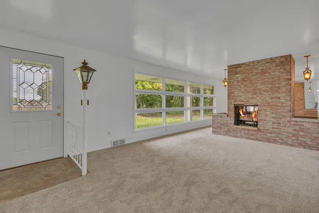 a view of a livingroom with an empty space and a fireplace