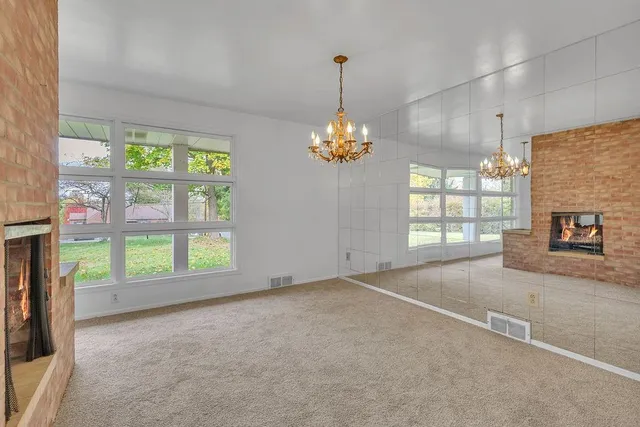 a view of an empty room with a fireplace and a window