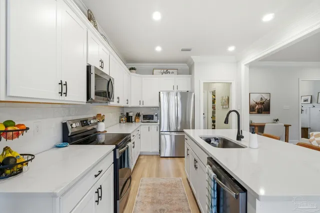a kitchen with appliances a sink and a refrigerator