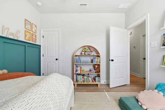 a bedroom with a large bed dresser and window
