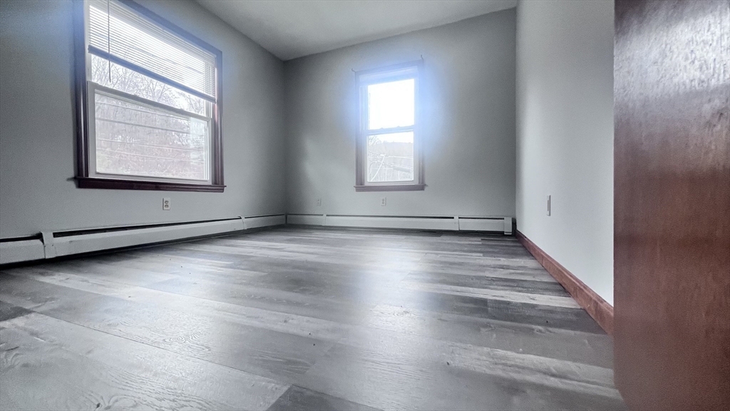 315 Woronoco Road Russell, MA 01071 - Photo 22 of 42 an empty room with wooden floor and windows