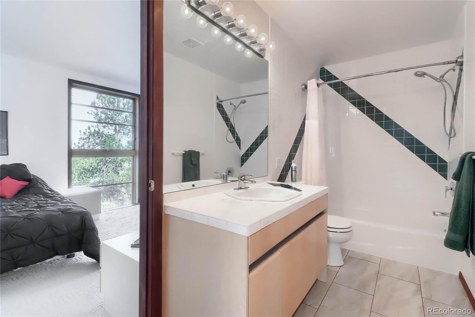 40273 County Road 13 Elizabeth, CO 80107 - Photo 38 of 40 a en suite bathroom with a sink and mirror with toilet