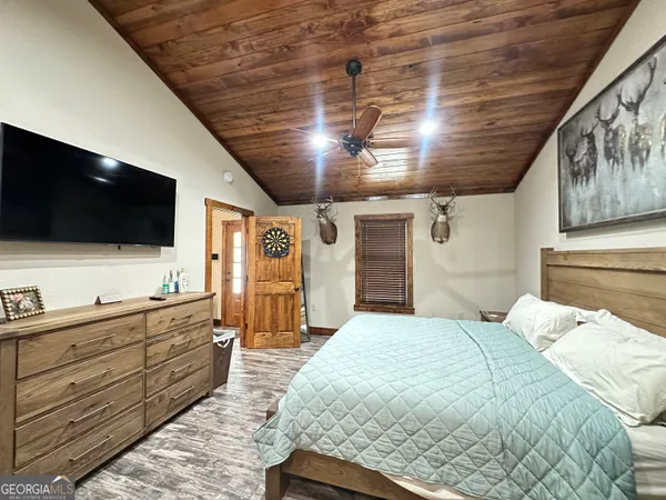 a large bedroom with a large bed and a flat screen tv