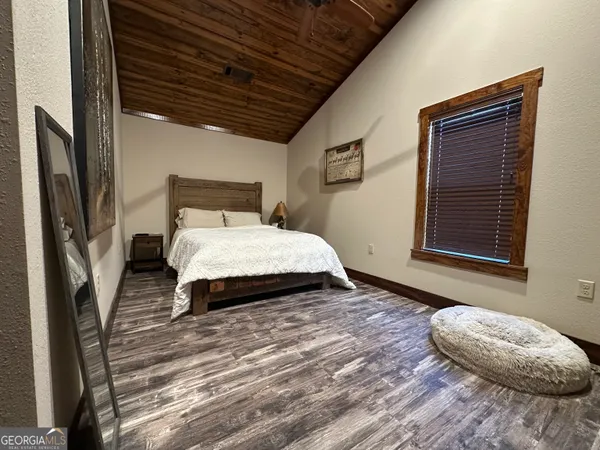 a bedroom with a bed wooden floor and a window
