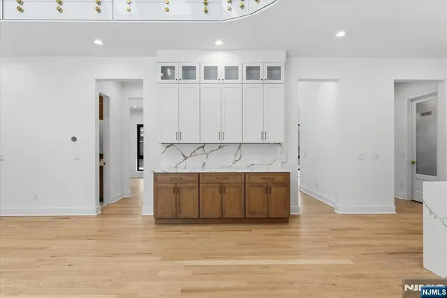 a large white kitchen with granite countertop white cabinets and stainless steel appliances