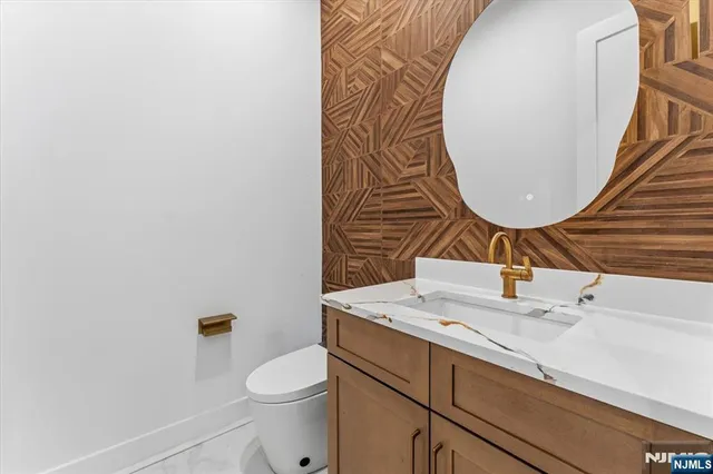 a bathroom with a sink mirror vanity and toilet