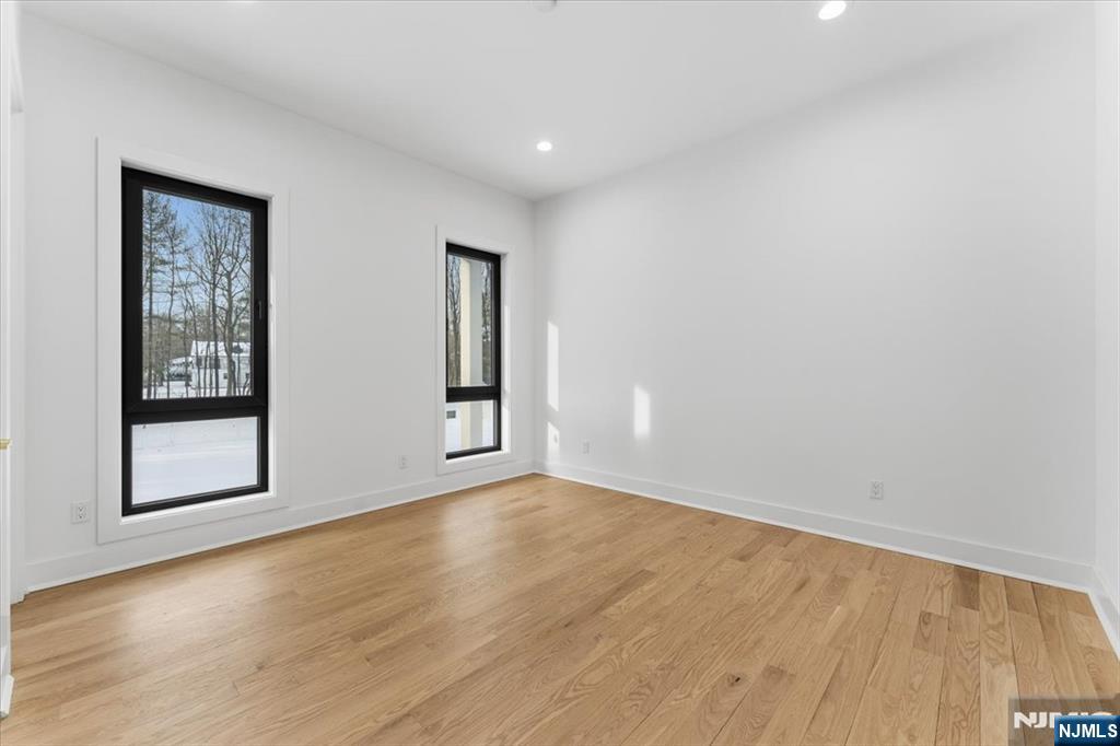 83 Falcon Road Livingston, NJ 07039 - Photo 29 of 34 a view of an empty room with wooden floor and a window