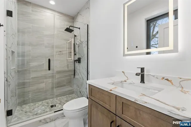 a bathroom with a sink a toilet and shower