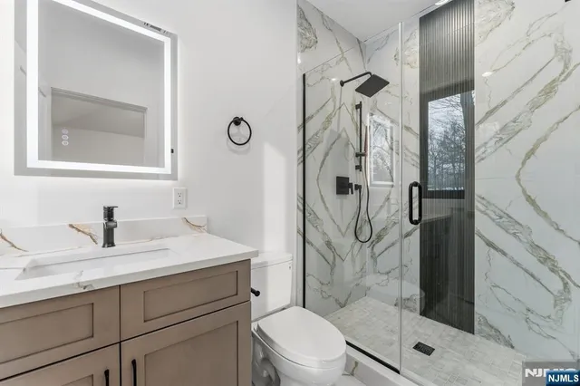 a bathroom with a granite countertop sink toilet and shower