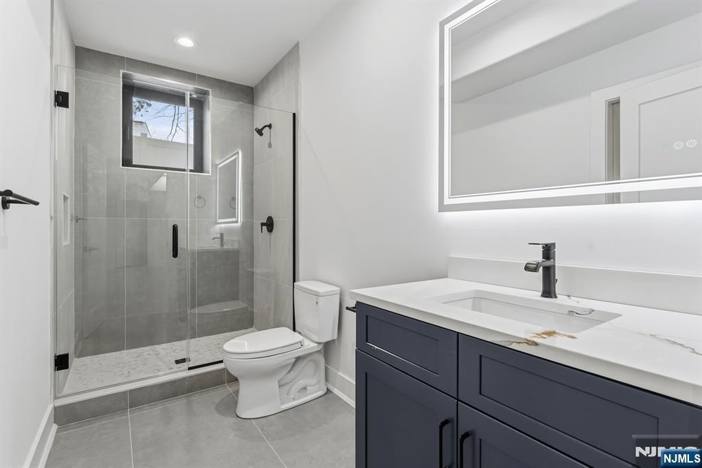 83 Falcon Road Livingston, NJ 07039 - Photo 9 of 34 a bathroom with a sink a toilet and shower
