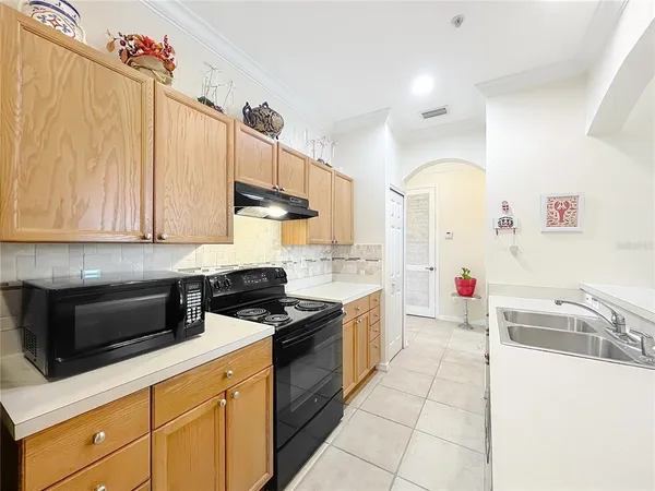 a kitchen with granite countertop a sink a stove and cabinets