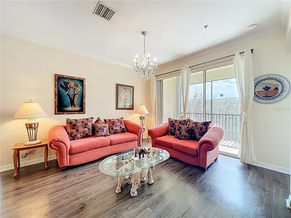 a living room with furniture large window and wooden floor