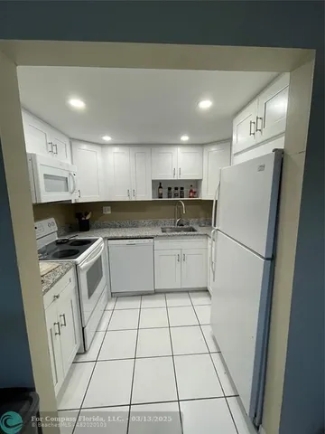 a kitchen with a refrigerator a sink and cabinets