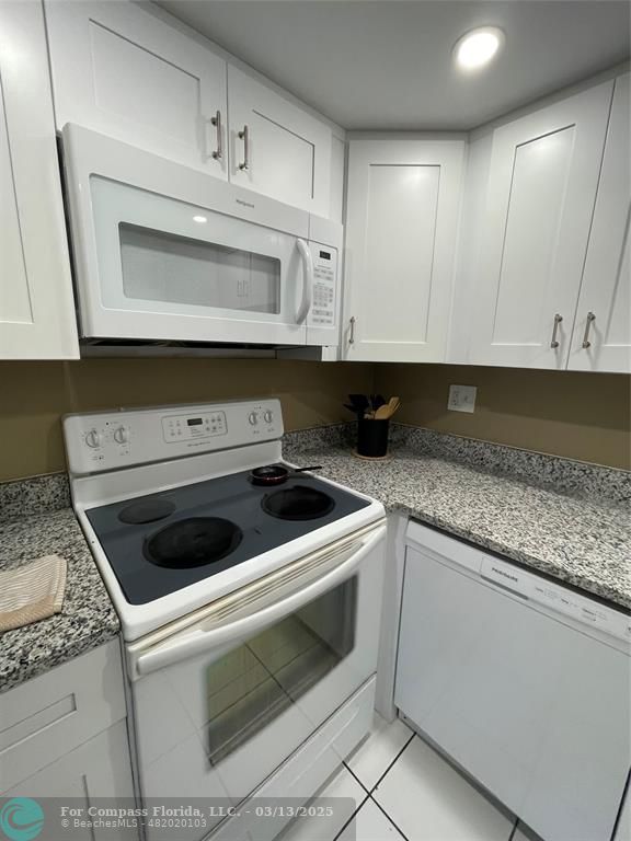 1400 Northeast 54th Street, Unit 203 Fort Lauderdale, FL 33334 - Photo 15 of 19 a kitchen with granite countertop white cabinets and white stove