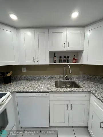 a kitchen with granite countertop a sink and cabinets