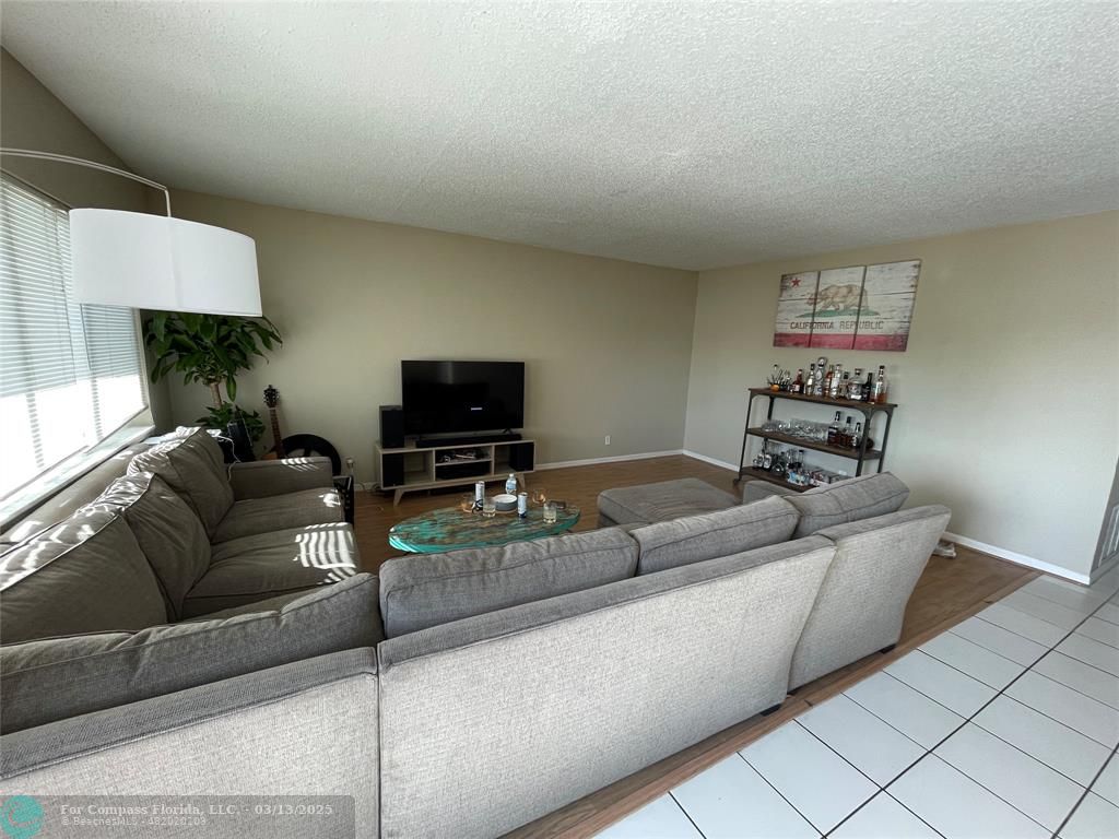1400 Northeast 54th Street, Unit 203 Fort Lauderdale, FL 33334 - Photo 17 of 19 a living room with furniture and a flat screen tv
