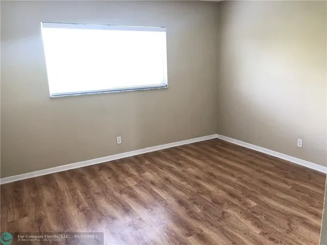 a view of a small space with wooden floor and a window