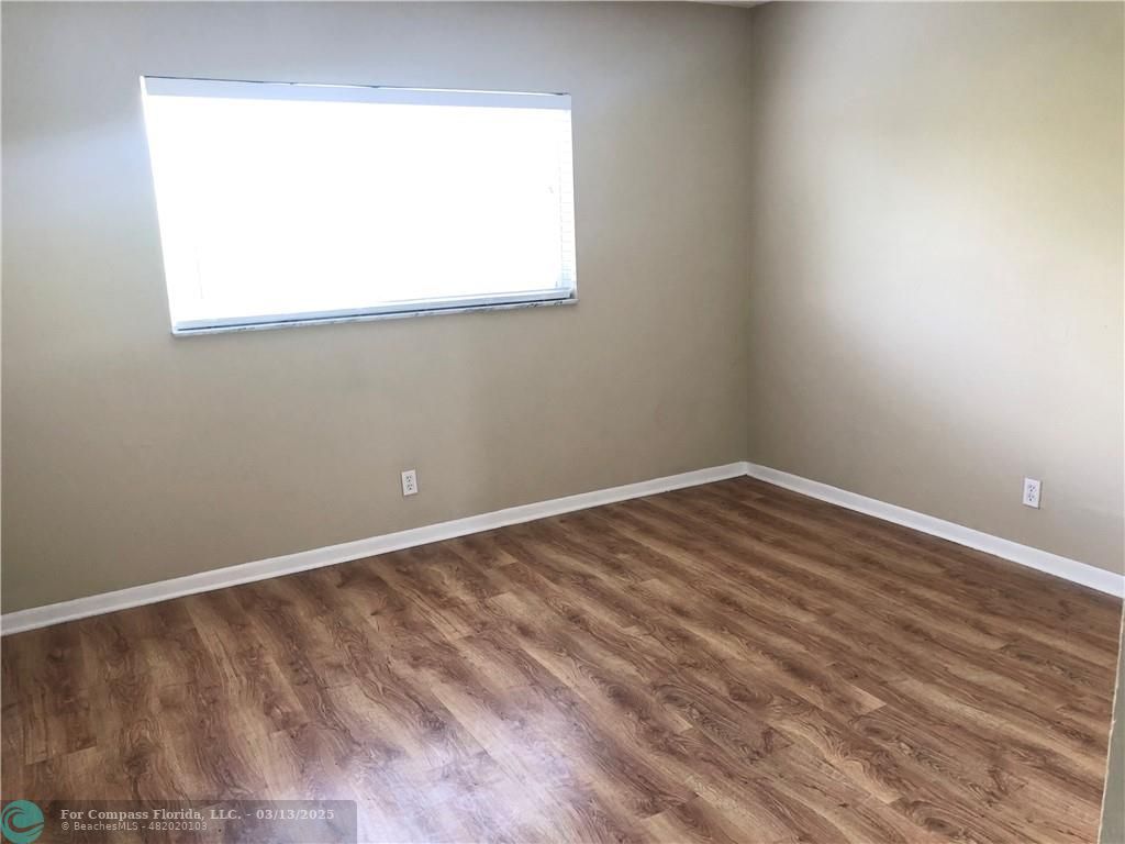 1400 Northeast 54th Street, Unit 203 Fort Lauderdale, FL 33334 - Photo 5 of 19 a view of a small space with wooden floor and a window
