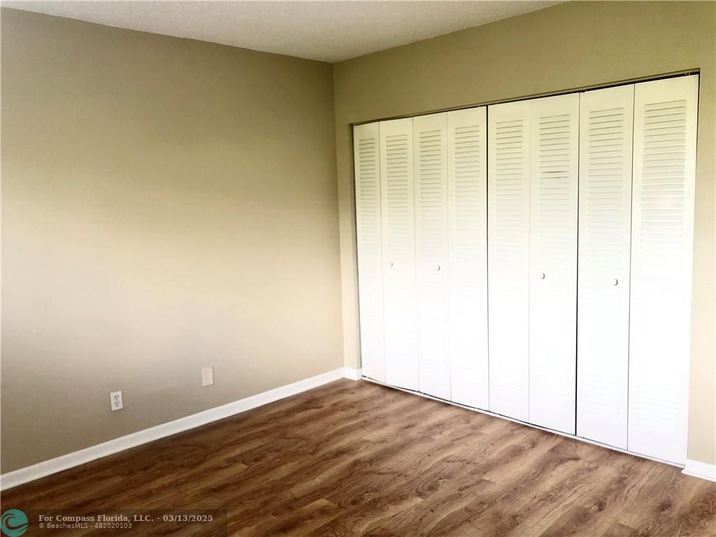 1400 Northeast 54th Street, Unit 203 Fort Lauderdale, FL 33334 - Photo 6 of 19 an empty room with wooden floor and a window