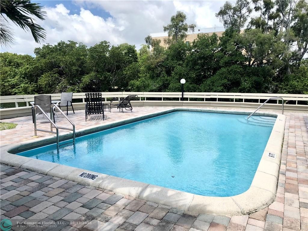 1400 Northeast 54th Street, Unit 203 Fort Lauderdale, FL 33334 - Photo 10 of 19 a view of a swimming pool with an outdoor seating