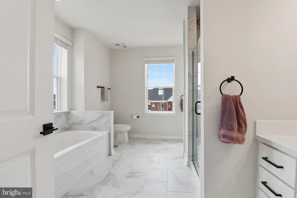 a bathroom with a tub sink and mirror