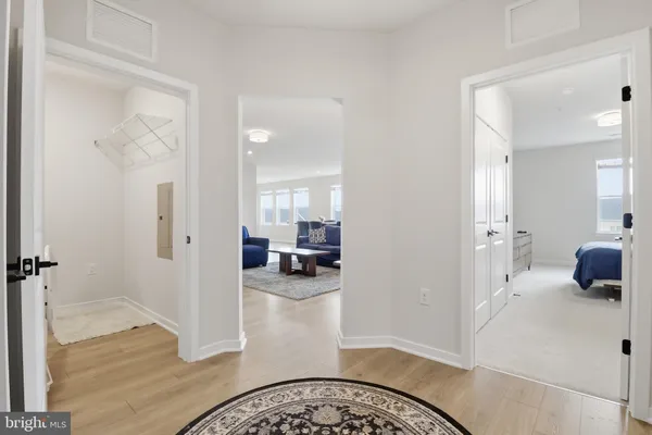 a view of a livingroom and a hallway with wooden floor
