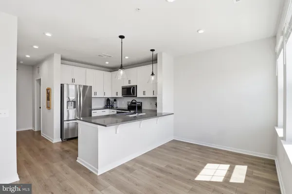 a kitchen with stainless steel appliances a refrigerator sink and microwave