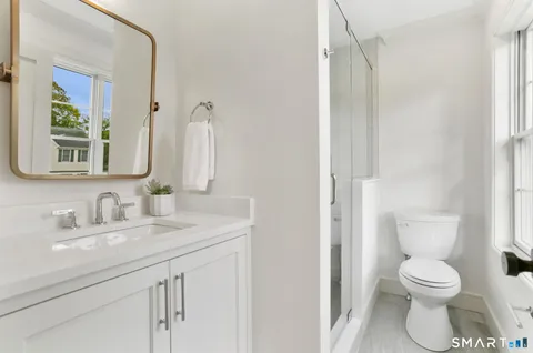 a bathroom with a toilet sink and mirror