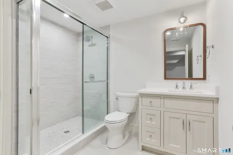 a bathroom with a toilet sink shower and mirror