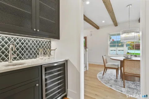 a kitchen with a sink a microwave a dining table and chairs