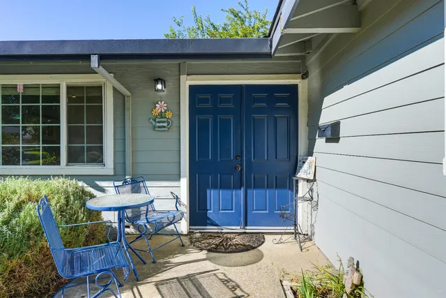 a front view of a house with a chairs and table in a patio