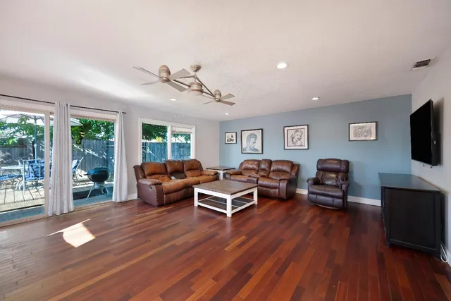 a living room with furniture flat screen tv and wooden floor