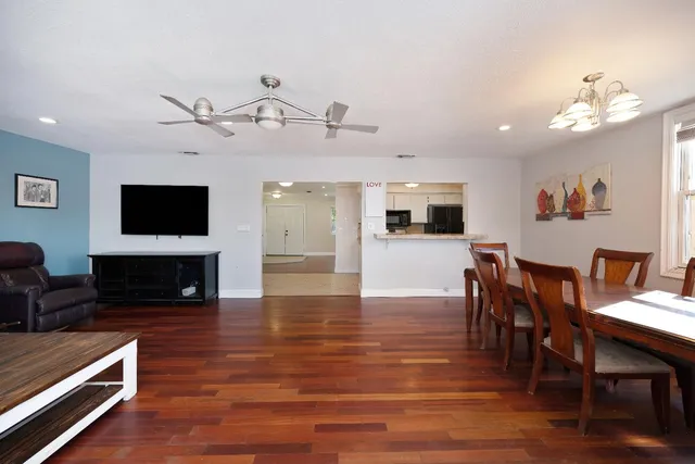 a living room with furniture a dining table and a flat screen tv