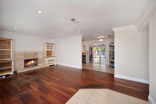 a view of empty room with wooden floor and fireplace