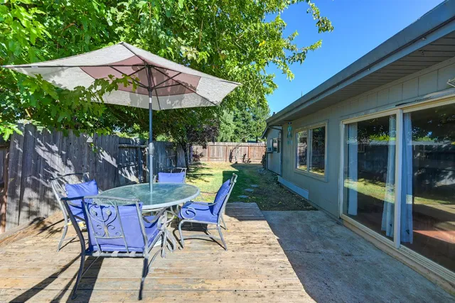 a view of a house with a yard and large tree