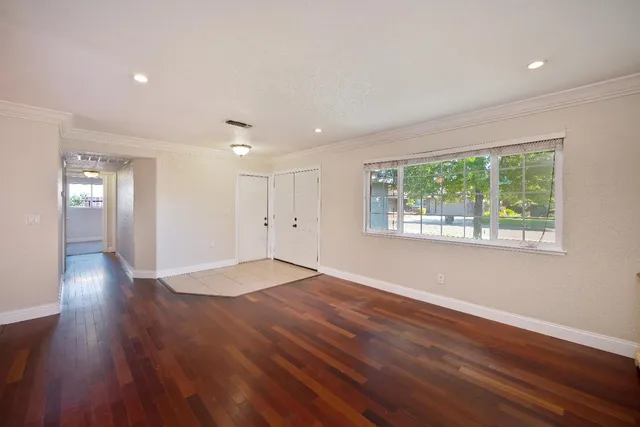 a kitchen with stainless steel appliances granite countertop a refrigerator oven a sink dishwasher and white cabinets with wooden floor