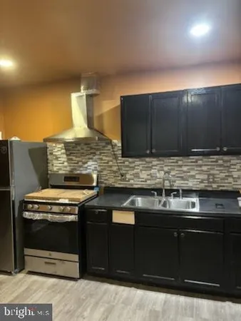 a kitchen with stainless steel appliances wooden cabinets and a stove top oven
