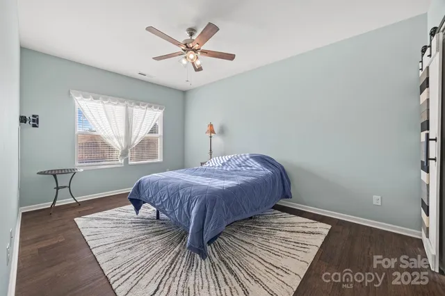 a bedroom with a large bed a chandelier and windows