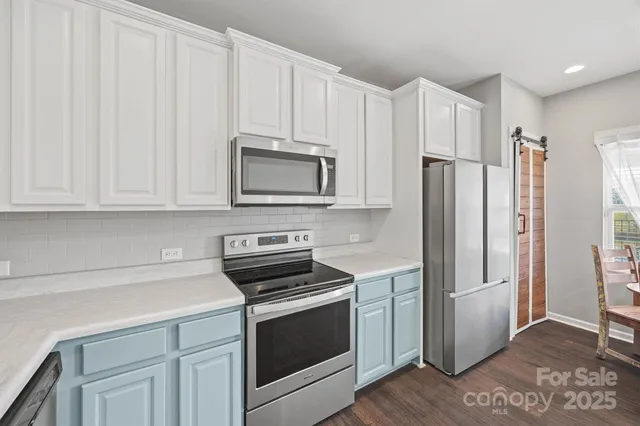 a kitchen with cabinets stainless steel appliances and wooden floor