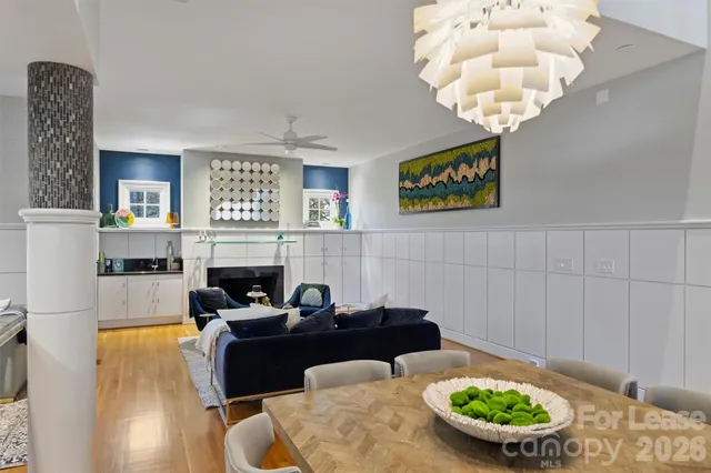 a living room with furniture a chandelier and a fireplace
