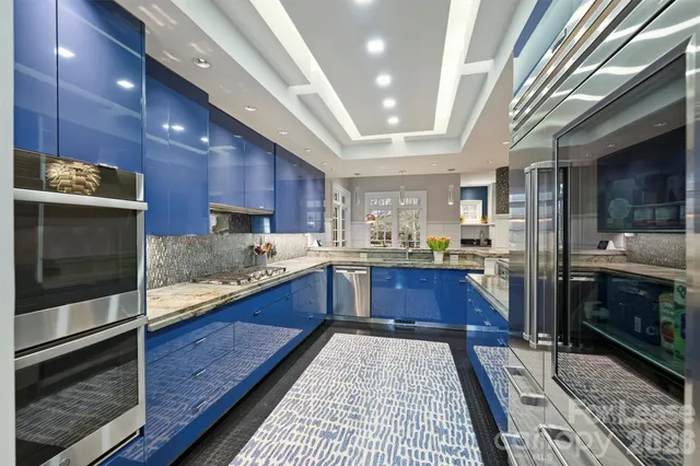 a large kitchen with stainless steel appliances wooden cabinets and a counter top