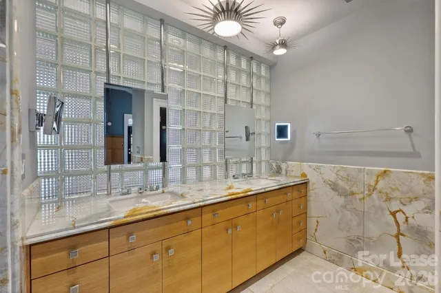 a bathroom with a granite countertop sink a large mirror and vanity